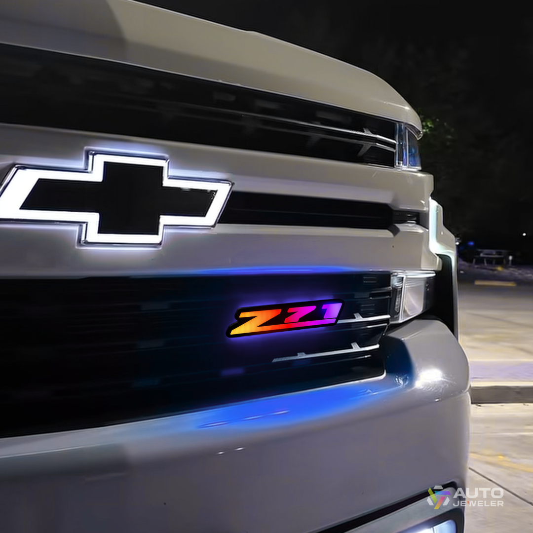 AutoJeweler RGB Z71 Flow Series grille emblem installed on Chevy truck showing multicolor rainbow lighting effect at night