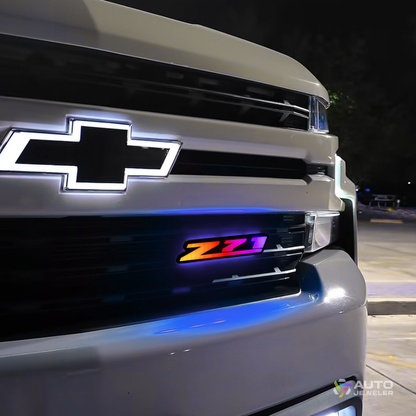 AutoJeweler RGB Z71 Flow Series grille emblem installed on Chevy truck showing multicolor rainbow lighting effect at night