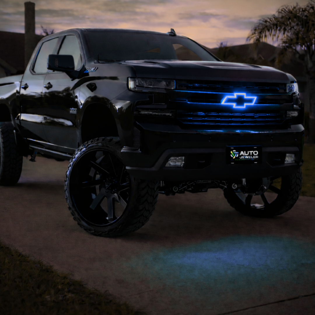 Black Chevy Silverado truck with blue RGB LED grille emblem illuminated at dusk installed on front grille