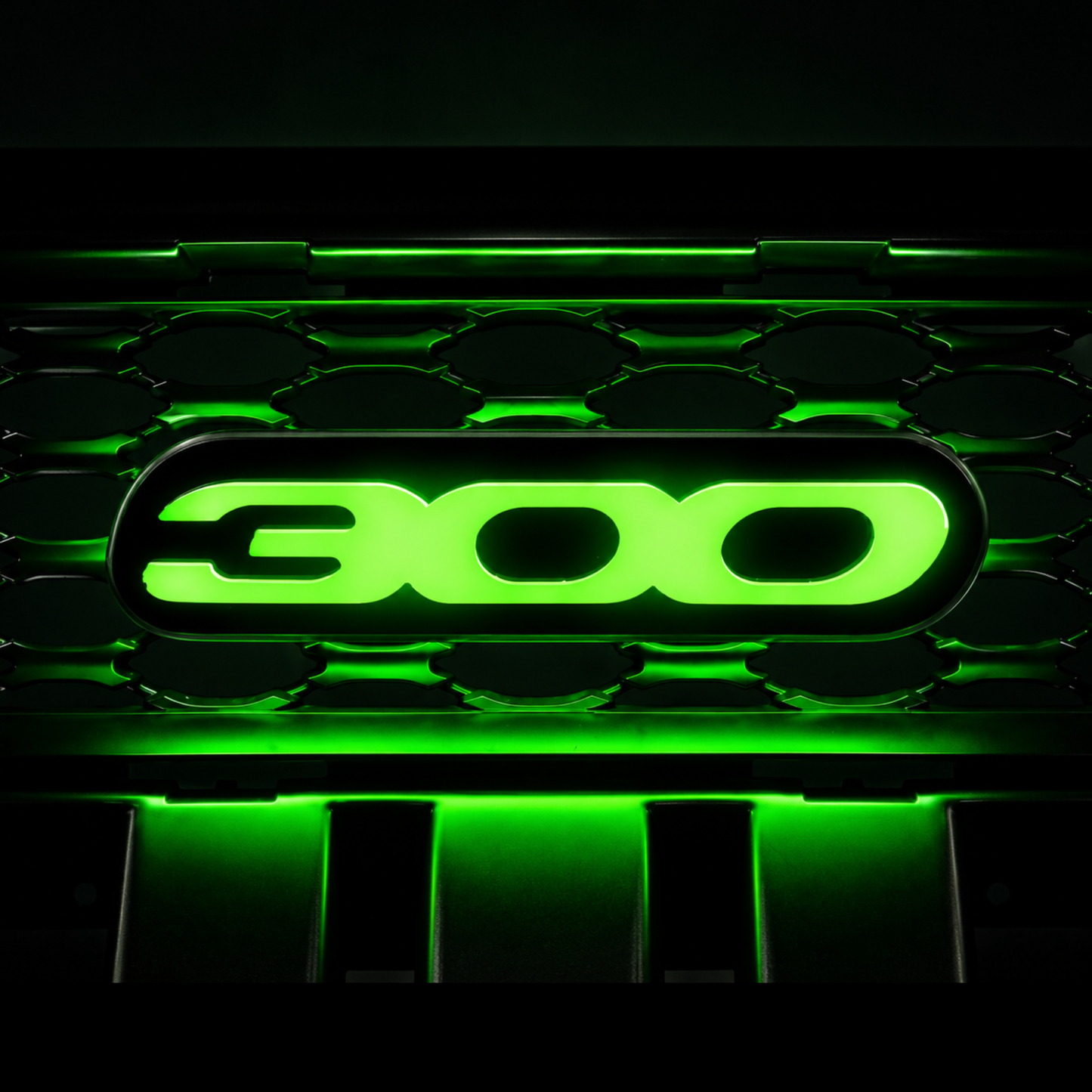 Chrysler 300 illuminated grille emblem glowing bright green with high-output LEDs, gloss black acrylic faceplate, and custom luxury sedan grille installation.