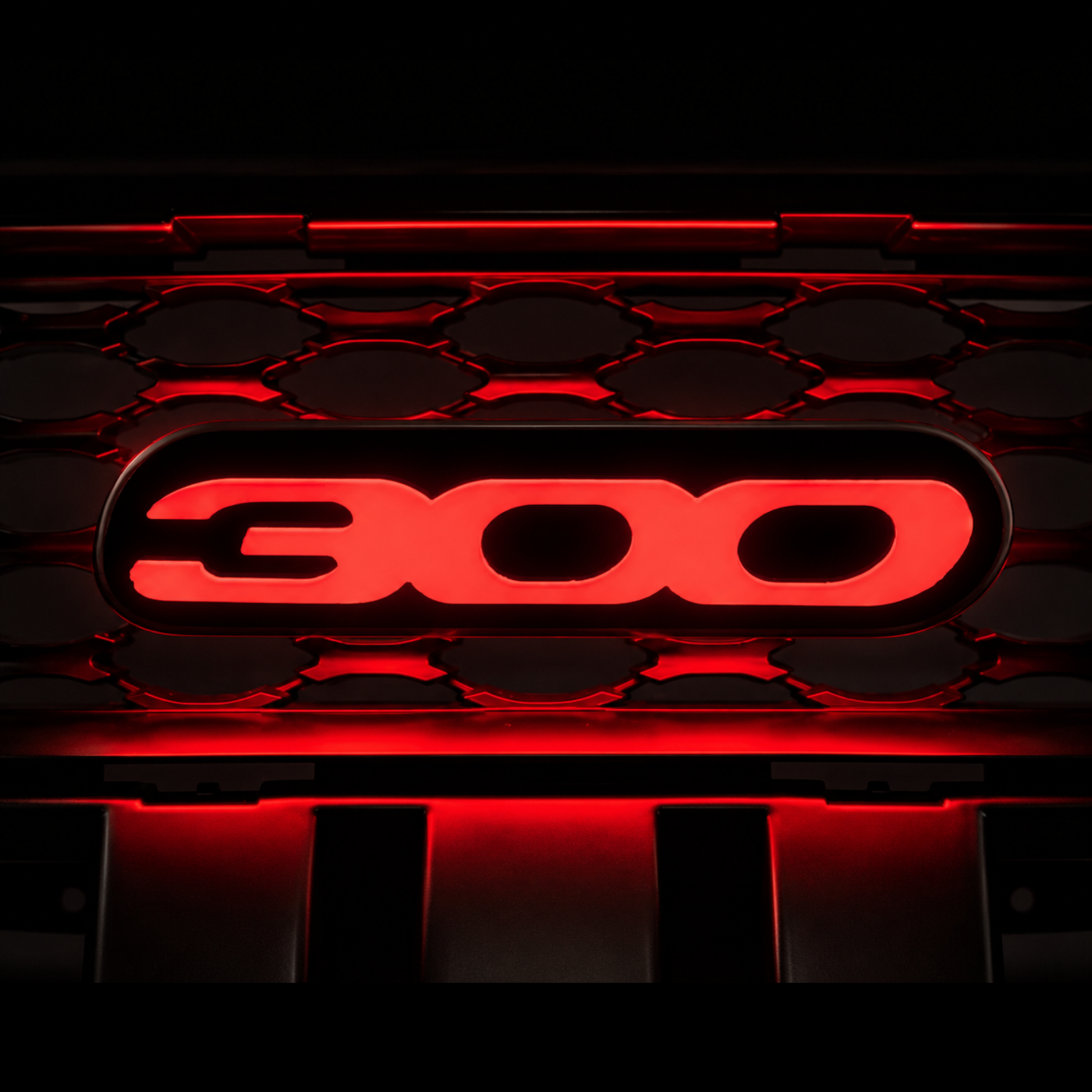 Chrysler 300 illuminated grille emblem glowing bright red with premium LED lighting, gloss black housing, and aggressive custom grille installation appearance.