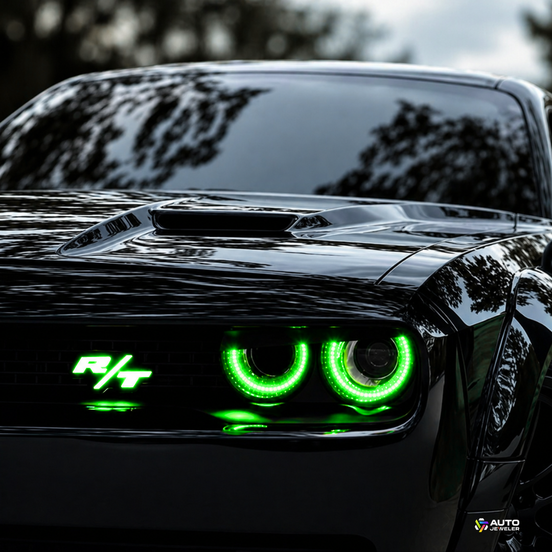 Dodge Challenger R/T front view with green LED grille emblem and halo headlights illuminated, showcasing custom automotive lighting upgrade by AutoJeweler