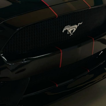 Close-up of a black Ford Mustang with a prominent logo on the grille.
