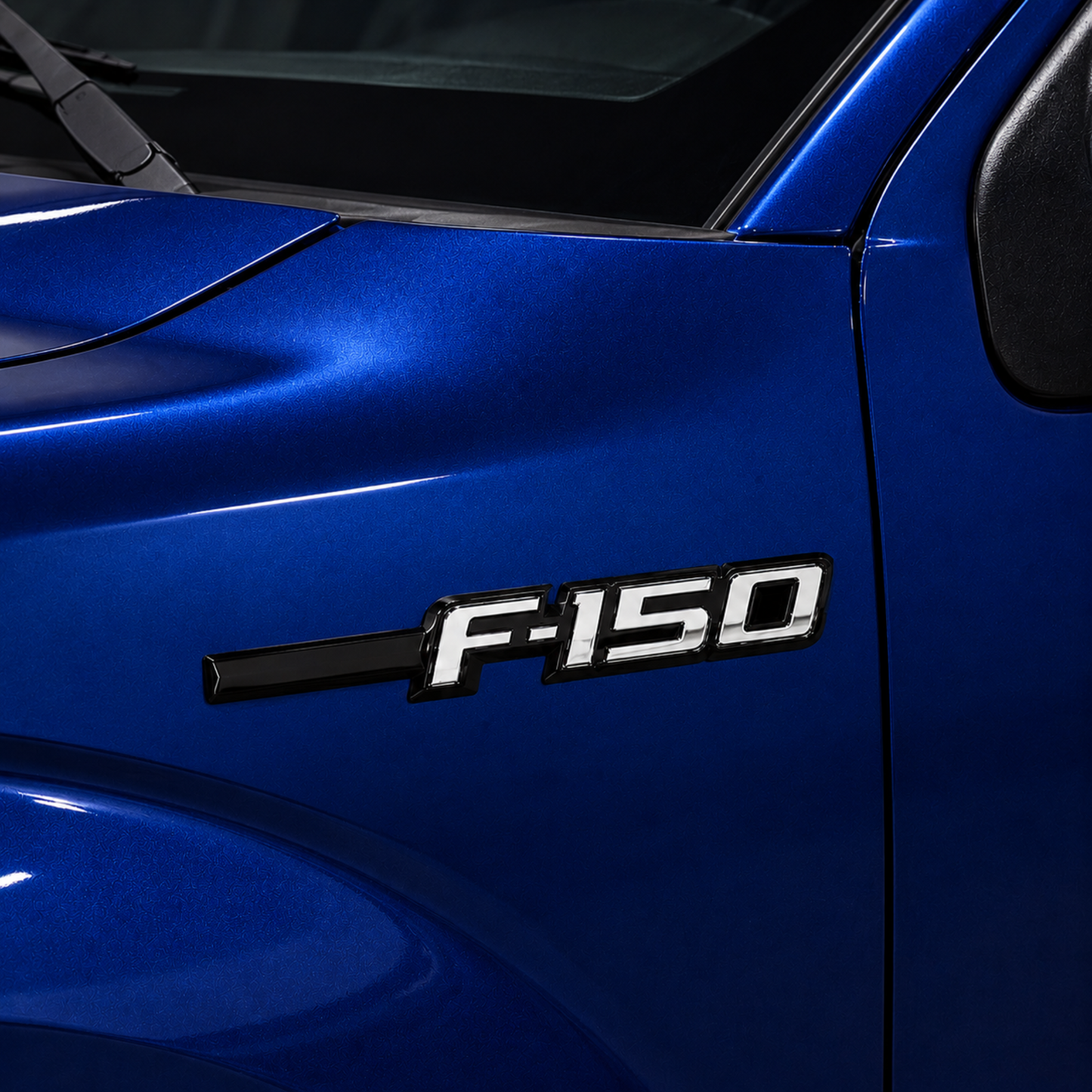 Ford F-150 LED Fender Emblem installed on a blue 2009-2014 F-150 truck shown power off with black and chrome finish and OEM style fender badge appearance.