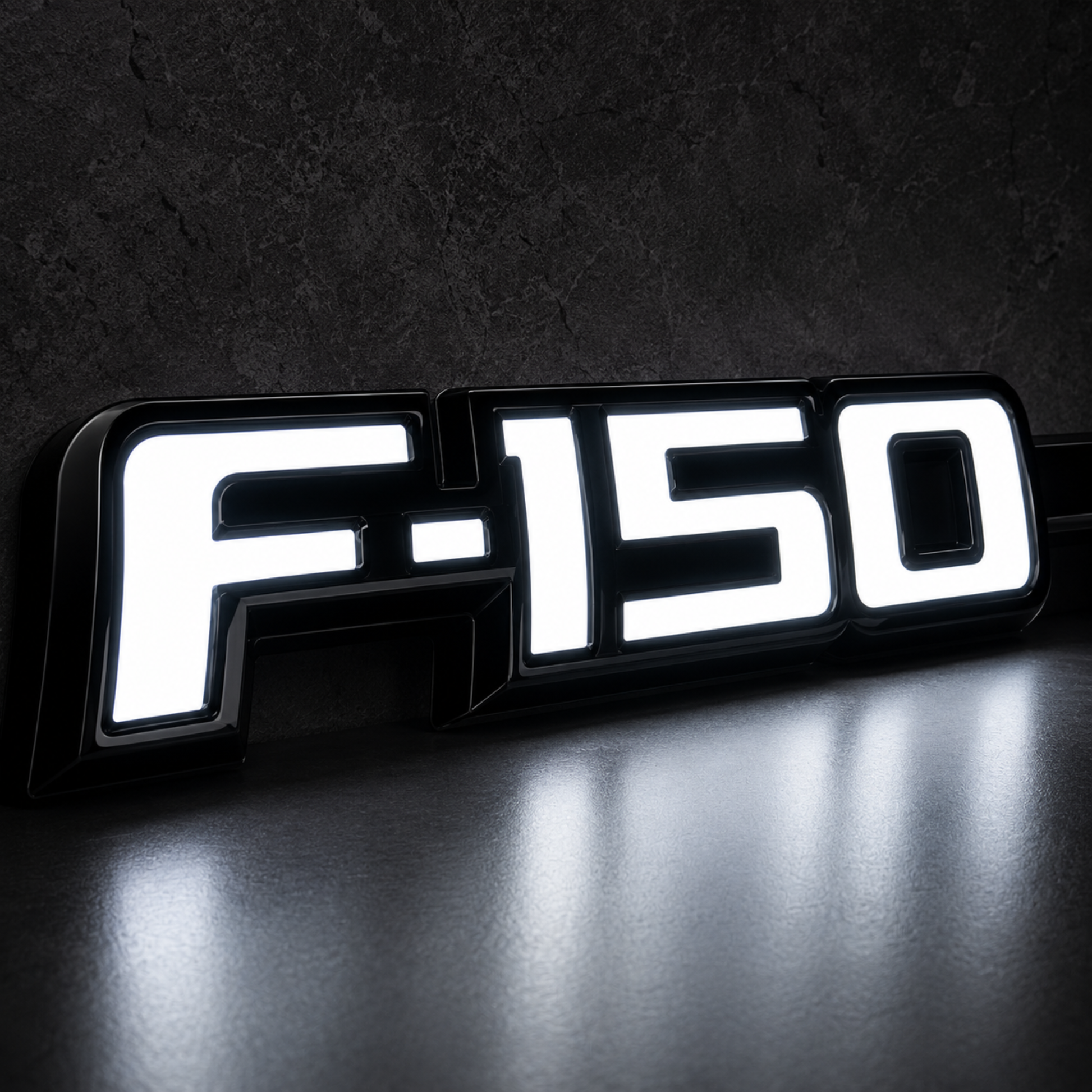 Close-up of Ford F-150 LED Fender Emblem for 2009-2014 trucks showing bright white illumination with black housing and chrome OEM style lettering.