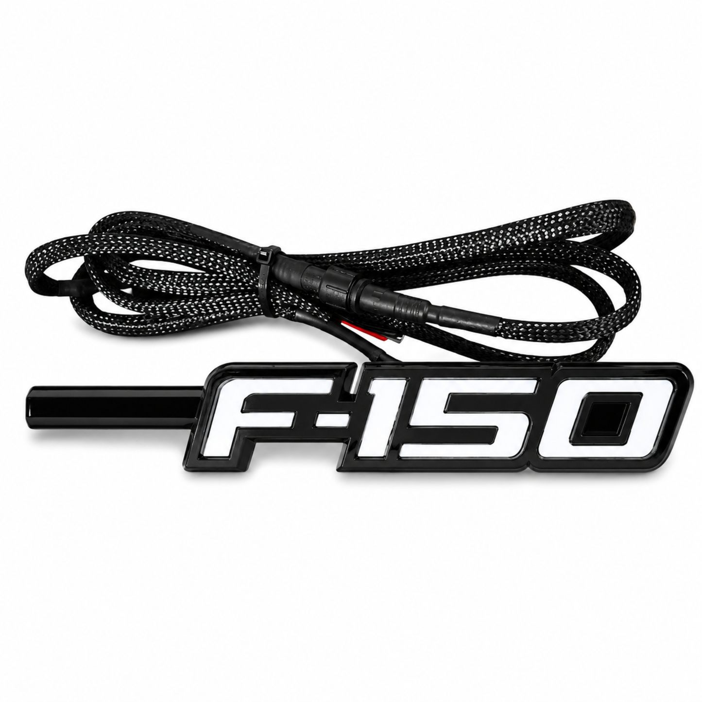 Angled view of Ford F-150 LED Fender Emblem for 2009-2014 models with black and chrome housing, white LED illumination, and integrated wiring harness.