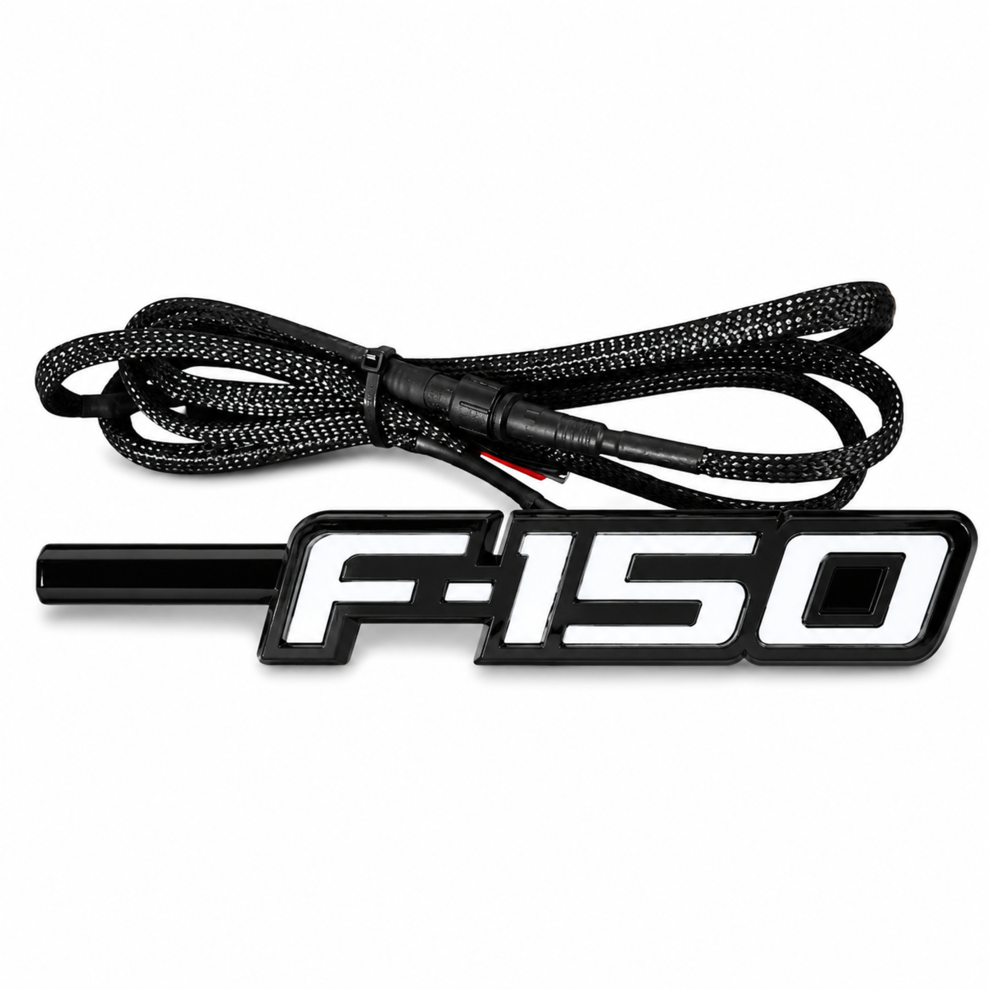 Angled view of Ford F-150 LED Fender Emblem for 2009-2014 models with black and chrome housing, white LED illumination, and integrated wiring harness.