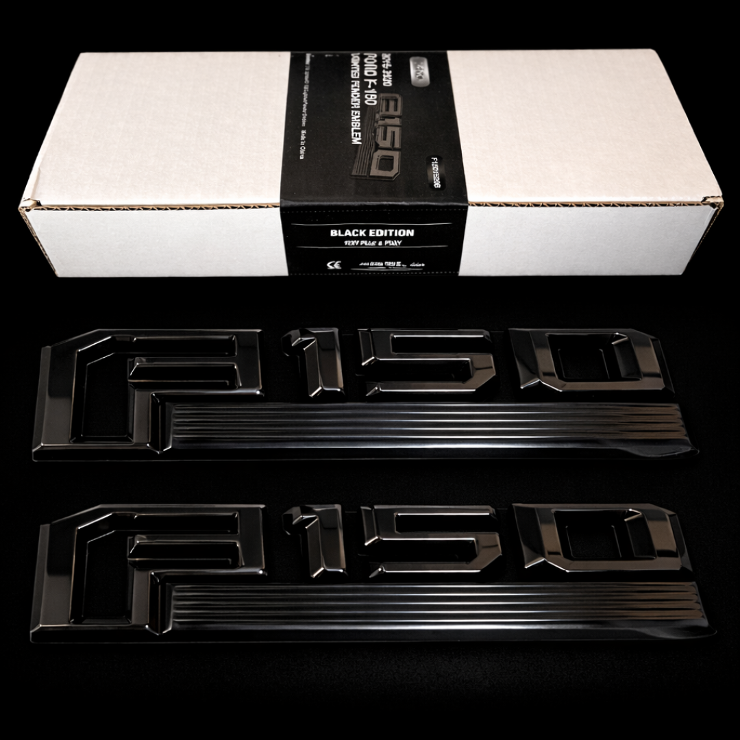 Black LED F-150 lighted fender emblem kit showing two gloss black emblems and retail box package contents on dark background.