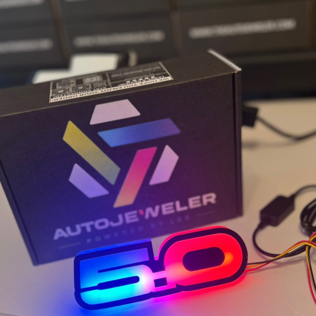 Ford Mustang 5.0 RGB Flow Series LED emblem demo lighting in red and blue with AutoJeweler packaging.