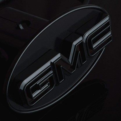 Detailed close-up of gloss black GMC LED hitch cover showing raised lettering and smooth black finish surface