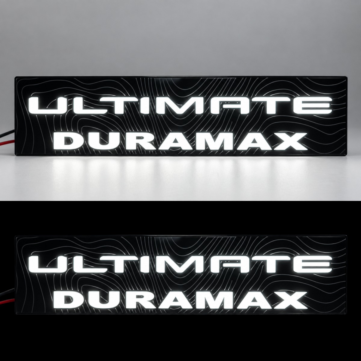 Close-up of gloss black GMC Sierra HD Duramax 6.6L fender badge illuminated white