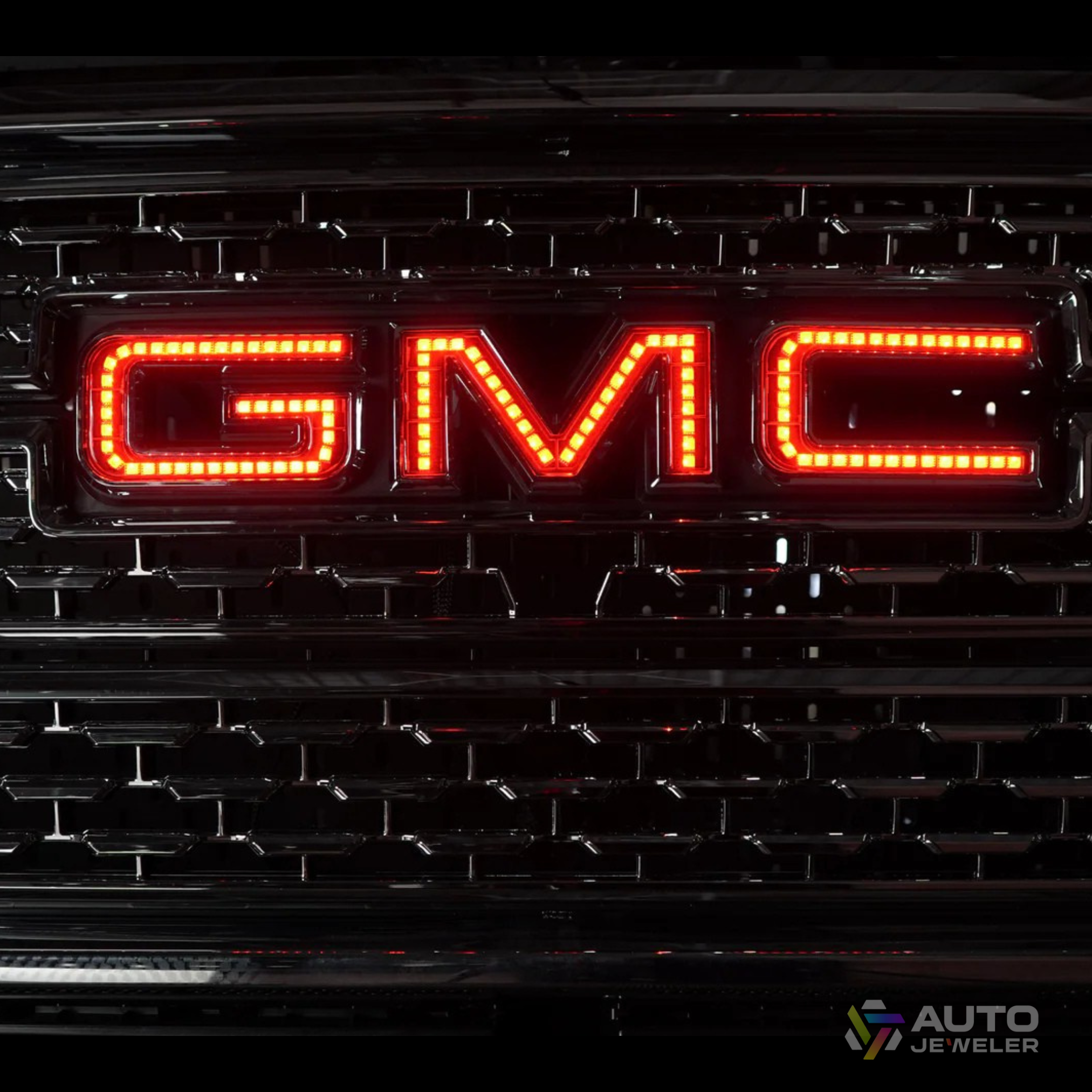 AutoJeweler RGBW GMC LED illuminated grille logo showing bright solid red output on a GMC Sierra front grille.