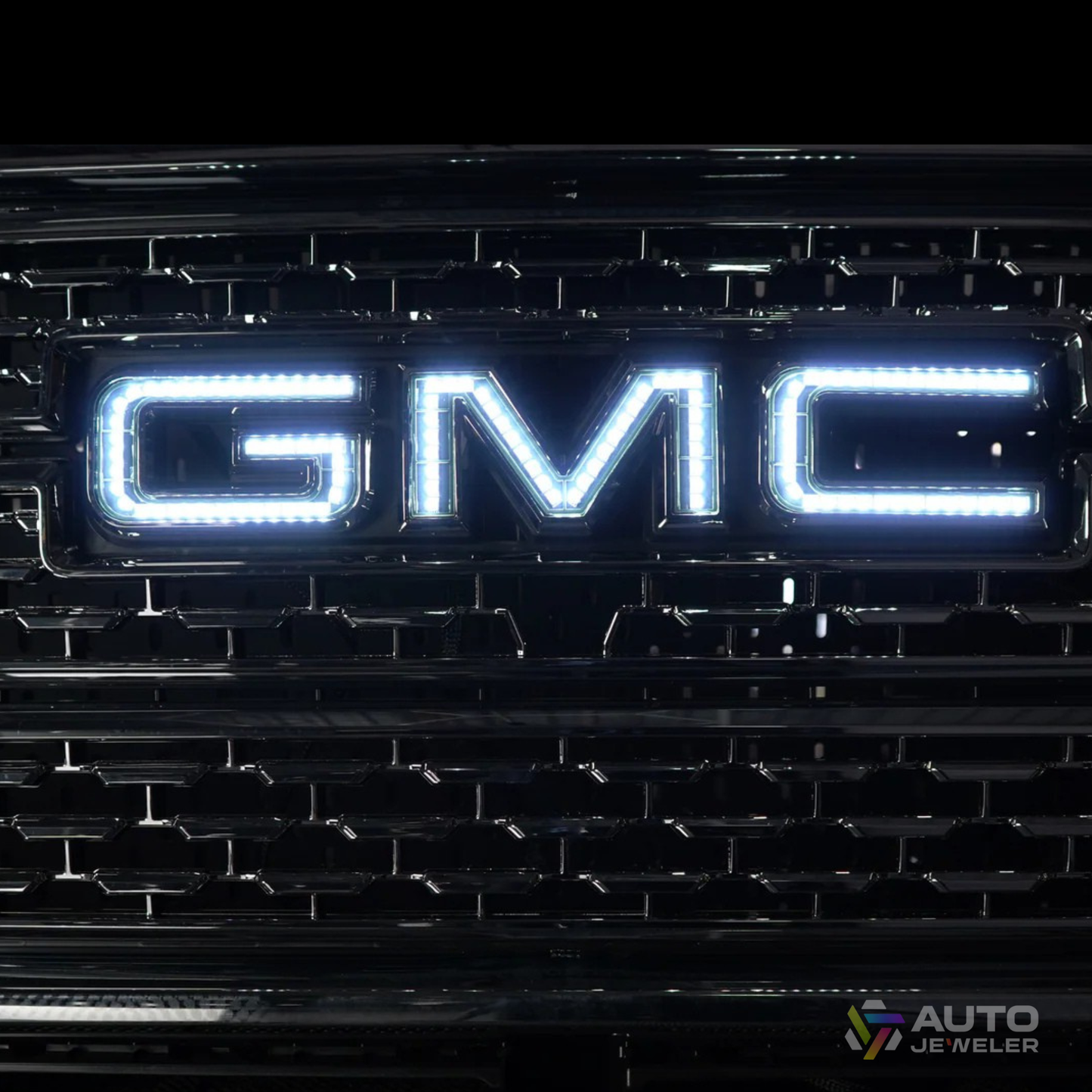 AutoJeweler white RGBW GMC LED illuminated grille logo showing bright pure white output on a GMC Sierra front grille.