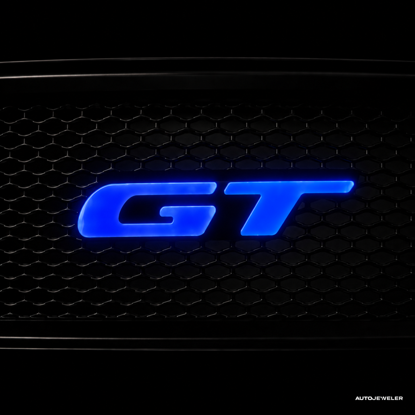 AutoJeweler Mustang GT Flow Series LED Badge illuminated in blue LED mode on a black honeycomb style grille.