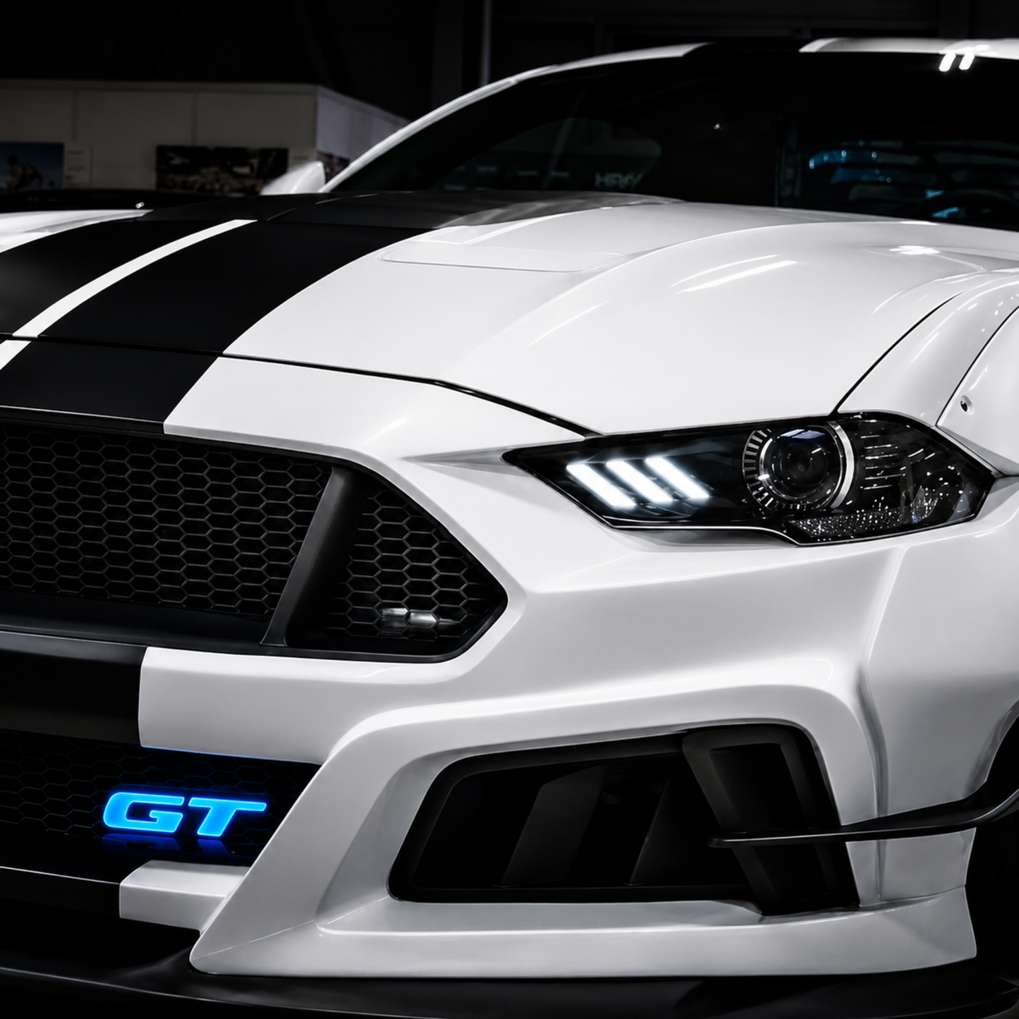Lifestyle photo of customized 2025 Ford Mustang GT at night with an AutoJeweler Premium LED Illuminated GT grille logo glowing bright blue.