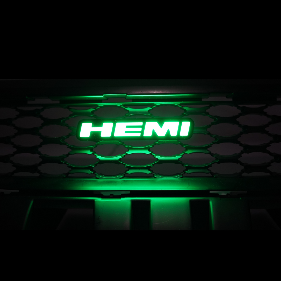 HEMI LED emblem glowing green installed on vehicle grille showing bright illuminated badge at night