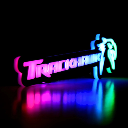 Jeep Trackhawk RGB Flow Series LED grille emblem shown in angled studio view with multicolor flow lighting and reflective surface