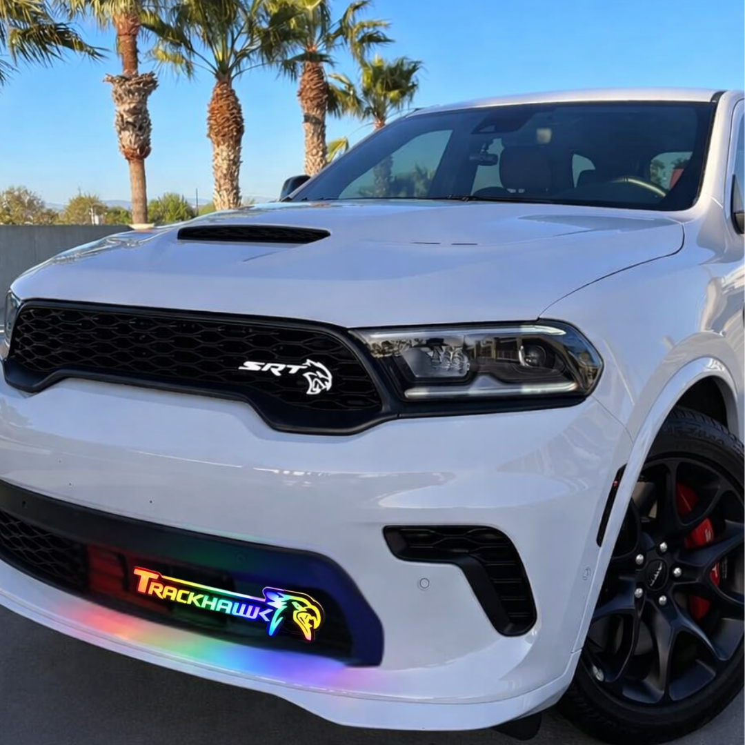 Jeep Trackhawk RGB Flow Series LED grille emblem installed on front bumper in daylight showing multicolor flow lighting