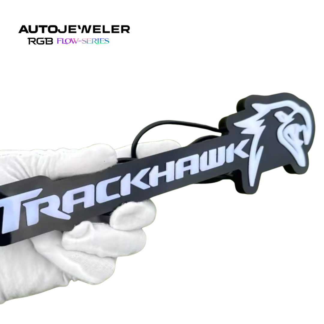 Jeep Trackhawk RGB Flow Series LED grille emblem shown handheld to demonstrate size, thickness, and rear wiring connection
