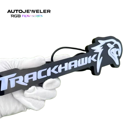 Jeep Trackhawk RGB Flow Series LED grille emblem shown handheld to demonstrate size, thickness, and rear wiring connection