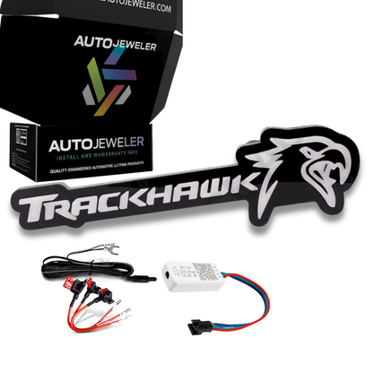 Jeep Trackhawk RGB Flow Series LED grille emblem kit contents including emblem, wiring harness, Bluetooth controller, fuse taps, and AutoJeweler packaging
