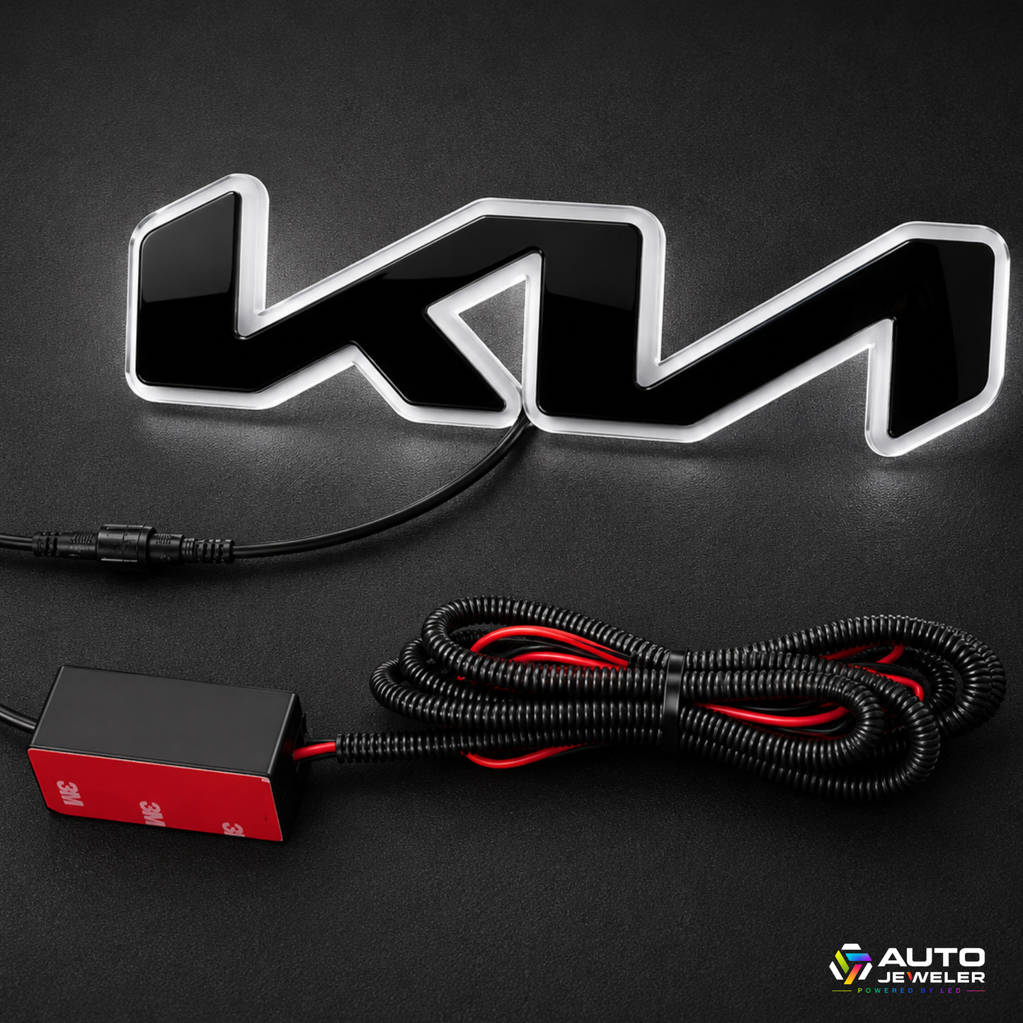A black and silver illuminated 'KIA' emblem light with a black power cable and a red/black control box, displayed on a dark background.