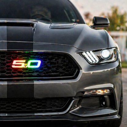Ford Mustang front grille close up with 5.0 RGB Flow Series LED emblem installed showing multicolor rainbow lighting