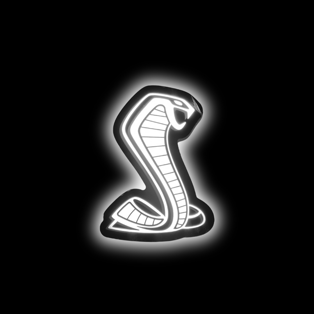 Mustang Cobra RGBW grille emblem glowing solid white in a dark environment, showcasing LED brightness and vivid illumination

