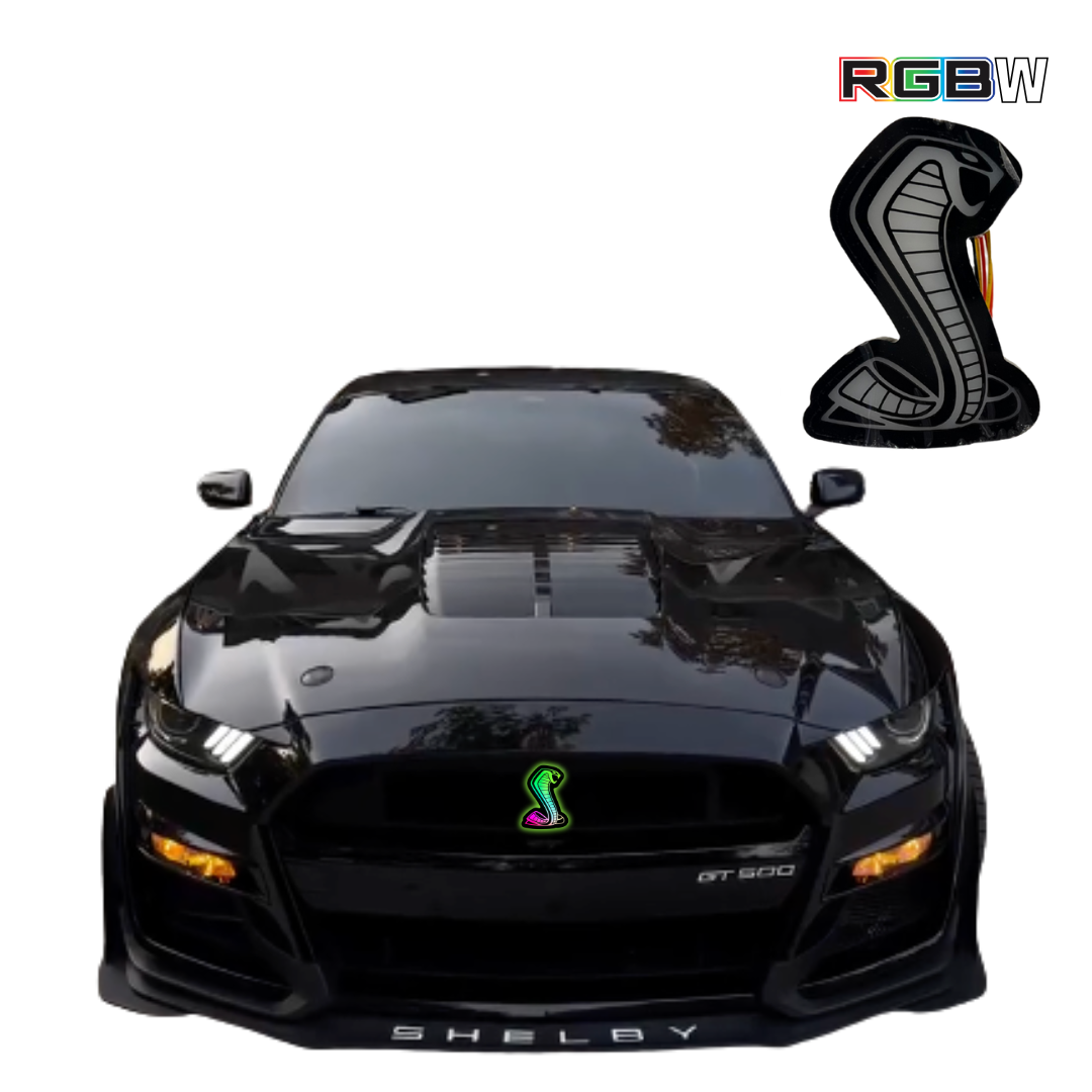 Front view of black Shelby GT500 Mustang with RGBW Cobra grille emblem installed, shown on white background with RGBW icon