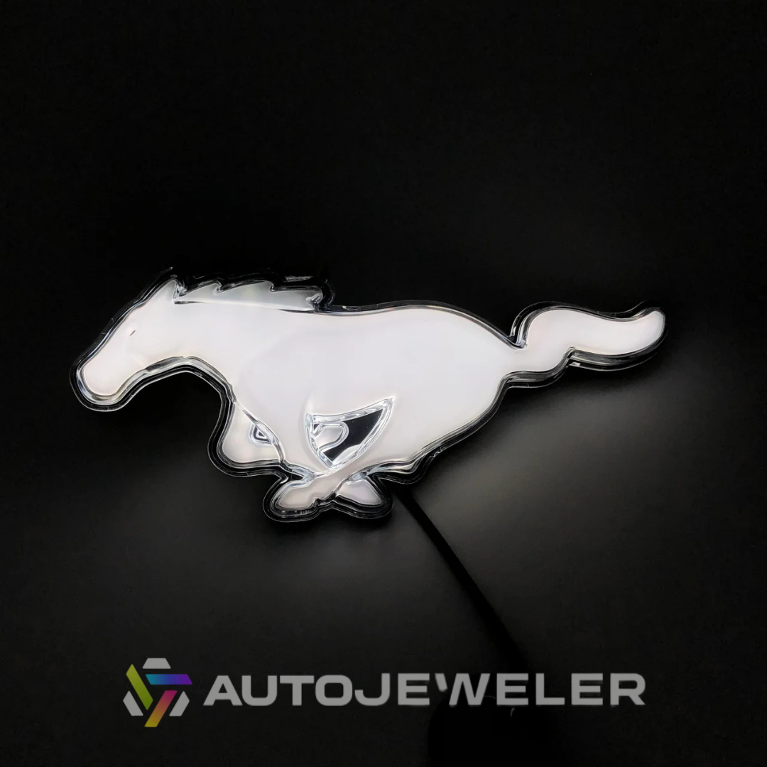 2015–2023 Ford Mustang S550 White LED illuminated pony grille emblem glowing on black background with AutoJeweler branding
