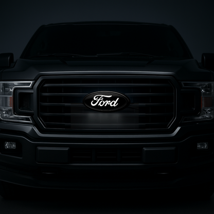 AutoJeweler 9-inch Ford LED grille emblem in gloss black; letters illuminate white. Kit contents and installation shown on turntable.