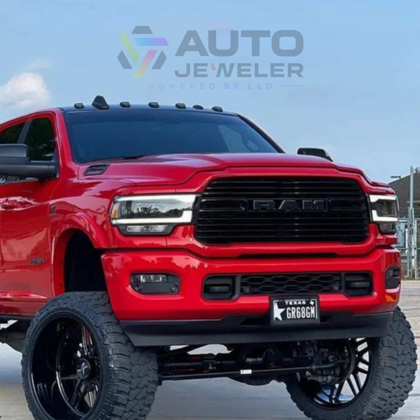 2019–2023 RAM 1500 with black RGB LED lighted grille emblem installed, front view on lifted red truck – AutoJeweler