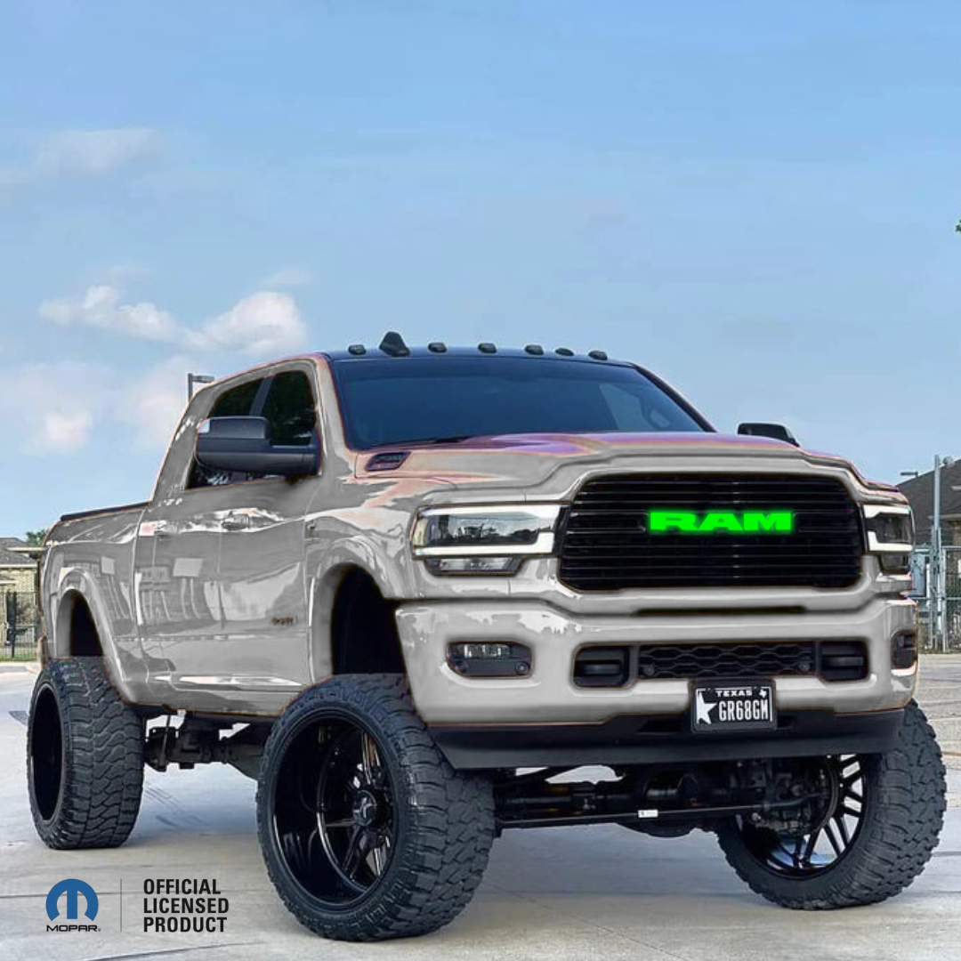 2019–2023 RAM 1500 with black RGB LED grille emblem, illuminated green RAM letters, Mopar Official Licensed Product, color-changing LED truck emblem installed on lifted RAM 1500.