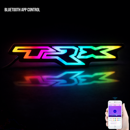 RAM TRX RGB Flow Series LED emblem with multi-color glow reflected on glossy black surface