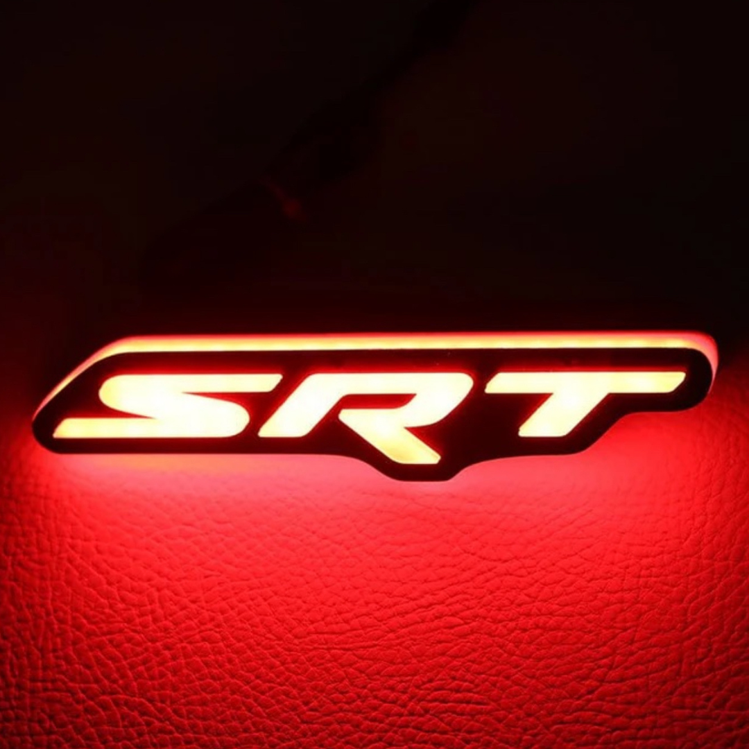 SRT illuminated grille emblem glowing with bold red LED lighting.