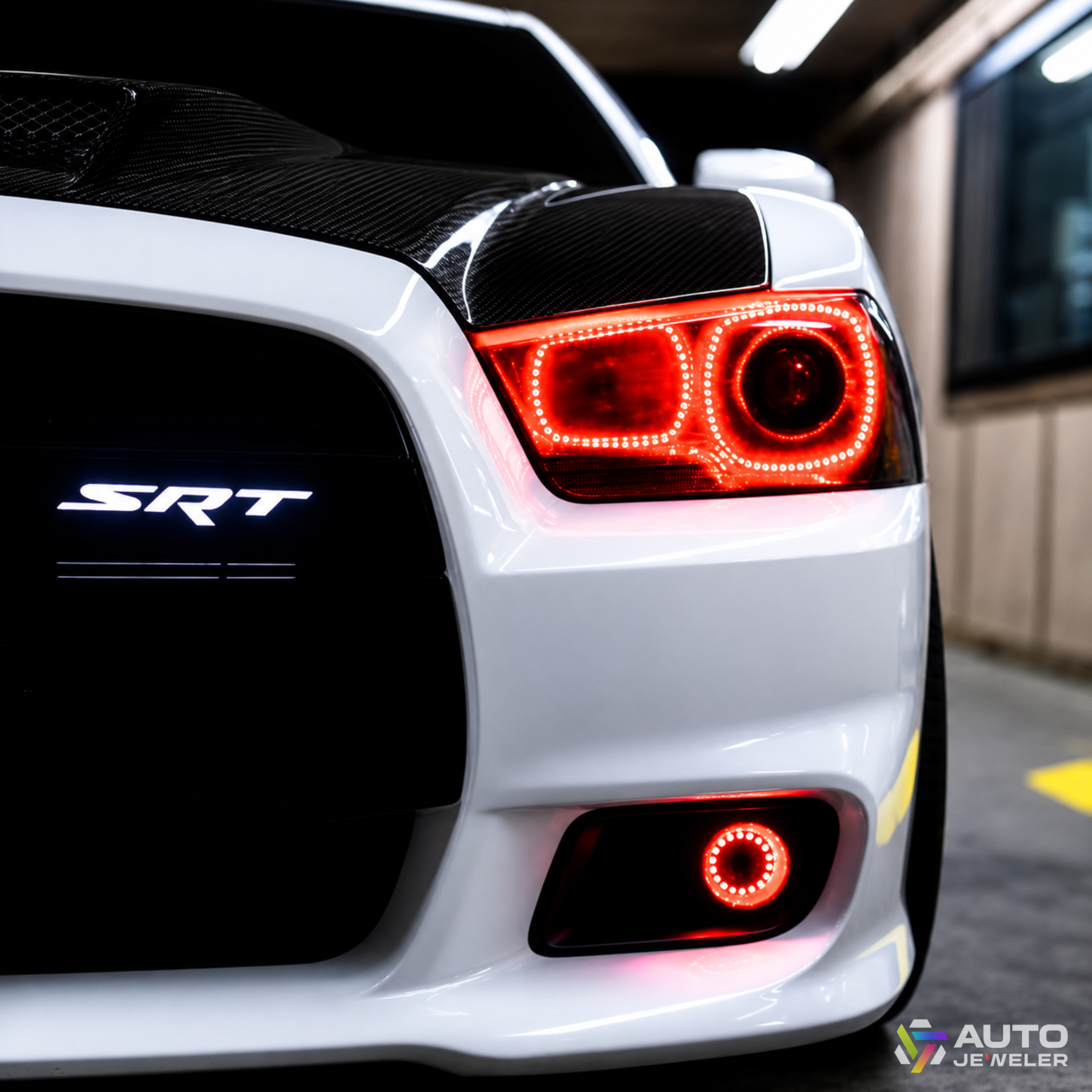 SRT LED grille emblem installed on white Dodge Charger with white illuminated badge and red halo lighting.