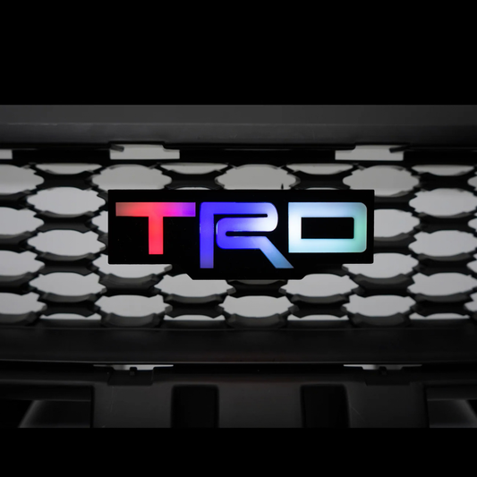 TRD Flow Series RGB LED grille emblem displaying multicolor rainbow lighting