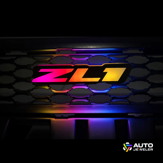 ZL1 Flow Series RGBW LED grille emblem installed on Camaro front grille with vibrant multicolor glow – AutoJeweler custom lighting.
